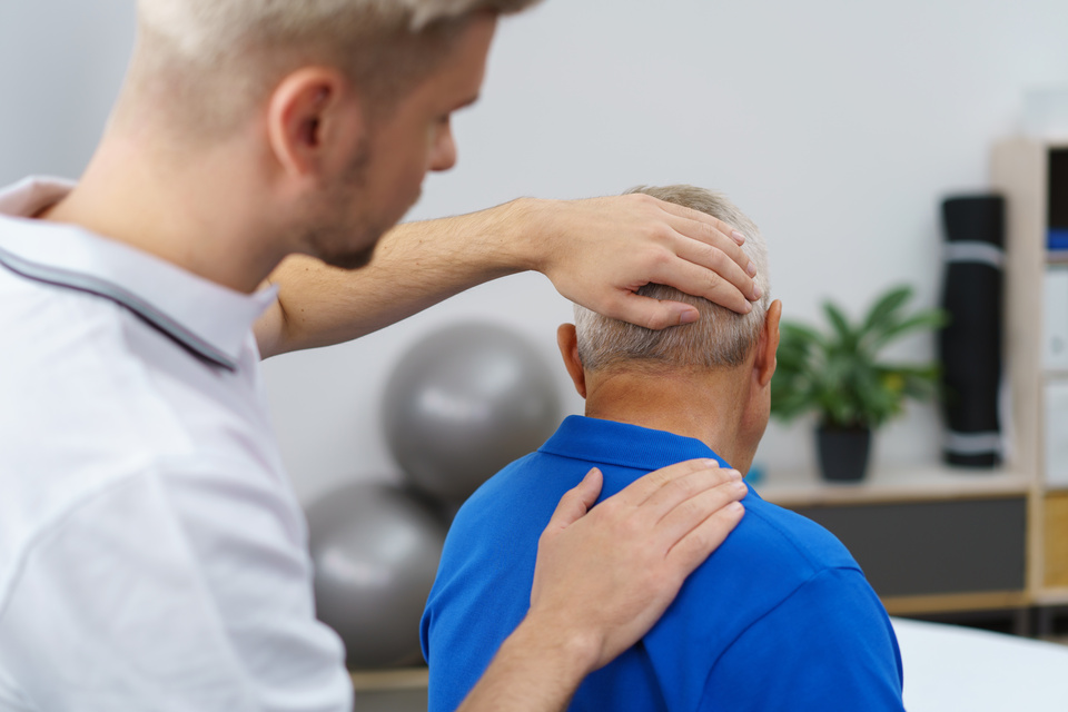 Physiotherapist giving neck and head massage to patient